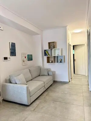 a living room with a couch in a room at Beachfront Apartment in Varkiza in Vari