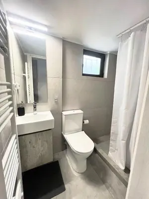 a bathroom with a white toilet and a sink at Beachfront Apartment in Varkiza in Vari