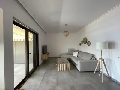 a living room with a couch and a table at Beachfront Apartment in Varkiza in Vari