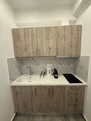 a kitchen with a sink and wooden cabinets at ATH Gray House in Athens
