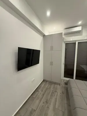 a living room with a flat screen tv on the wall at ATH Gray House in Athens