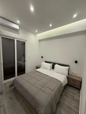 a bedroom with a large bed and a large window at ATH Gray House in Athens