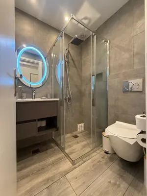 a bathroom with a shower and a toilet and a sink at ATH Gray House in Athens