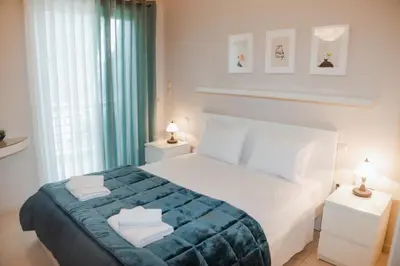 a bedroom with a white bed with towels on it at Marina's Sweet Home in Athens