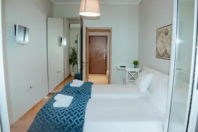 two beds in a small room with a hallway at Marina's Sweet Home in Athens