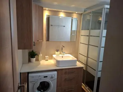 a bathroom with a sink and a washing machine at Marina's Sweet Home in Athens