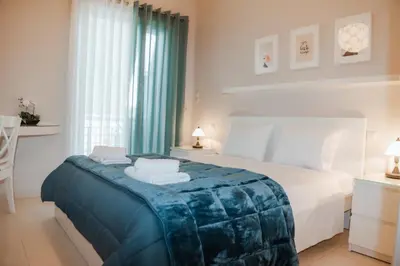 a bedroom with a bed with a blue blanket at Marina's Sweet Home in Athens