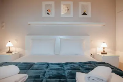 a white bedroom with a large bed with two lamps at Marina's Sweet Home in Athens