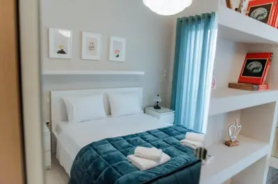 a bedroom with a bed with a green blanket at Marina's Sweet Home in Athens