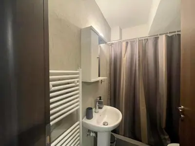 a white bathroom with a sink and a shower at Metaxourgio Apartments in Athens