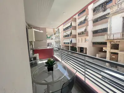 a balcony with a glass table in a building at Metaxourgio Apartments in Athens