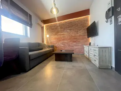 a living room with a couch and a brick wall at Metaxourgio Apartments in Athens