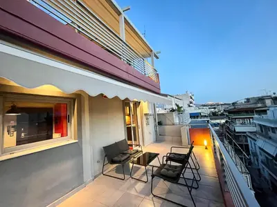 a balcony with chairs and a table on a building at Metaxourgio Apartments in Athens