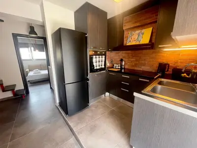 a kitchen with a black refrigerator and a sink at Metaxourgio Apartments in Athens