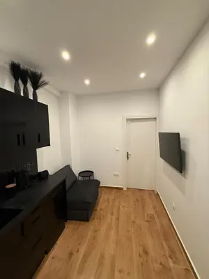 a living room with a couch and a flat screen tv at ATH Lux apartment in Athens