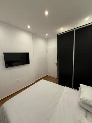 a bedroom with a large bed and a flat screen tv at ATH Lux apartment in Athens