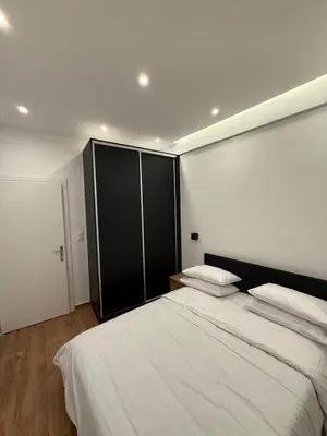 a bedroom with two beds and a black cabinet at ATH Lux apartment in Athens