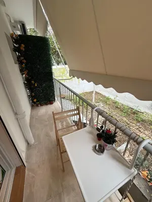 a white table and chairs on a balcony with a plant at ATH Cozy Studio in Athens