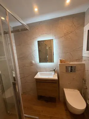 a bathroom with a sink and a toilet and a mirror at ATH Cozy Studio in Athens