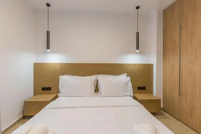 a bedroom with a large bed with white sheets and pillows at Raise Pagrati Serviced Apartments in Athens