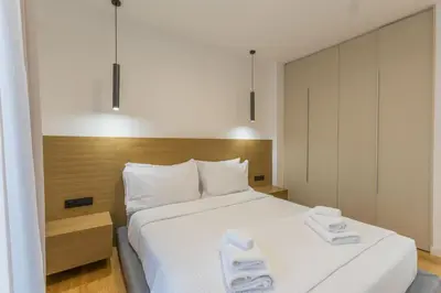 a bedroom with a large bed with two towels on it at Raise Pagrati Serviced Apartments in Athens