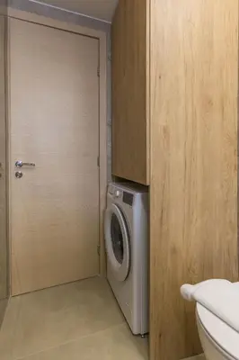 a washing machine in a bathroom with a door at Raise Pagrati Serviced Apartments in Athens