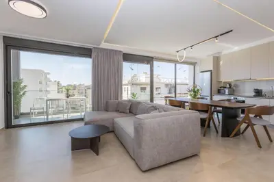 a living room with a couch and a table and a kitchen at Raise Pagrati Serviced Apartments in Athens