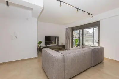 a living room with a couch and a tv at Raise Pagrati Serviced Apartments in Athens