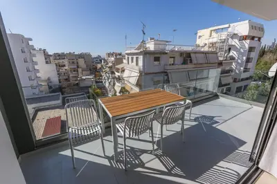 a table and chairs on a balcony with a view at Raise Pagrati Serviced Apartments in Athens