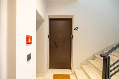 a hallway with a wooden door and stairs at Rooms151 Smart Suite in the Center of Athens 1st floor-2S in Athens