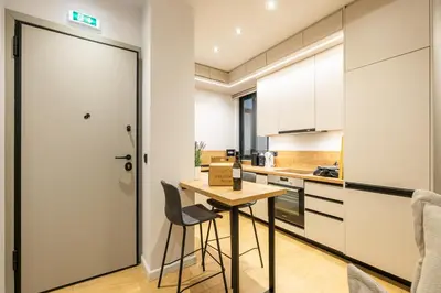 a kitchen with a small table and chairs next to a door at Rooms151 Smart Suite in the Center of Athens 1st floor-2S in Athens
