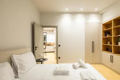 a bedroom with a bed with white sheets and towels on it at Rooms151 Smart Suite in the Center of Athens 1st floor-2S in Athens