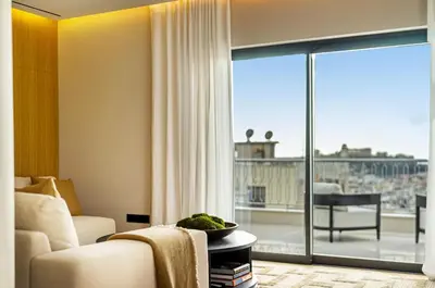 a living room with a couch and a large window at The Athenian Luxury Penthouse by GK Properties in Athens