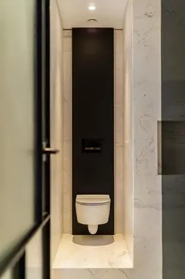 a toilet in a bathroom with a black wall at The Athenian Luxury Penthouse by GK Properties in Athens