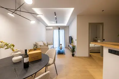 a living room with a table with a bottle of wine at Rooms151 Smart Suite in the Heart of Athens 1st floor-2B in Athens