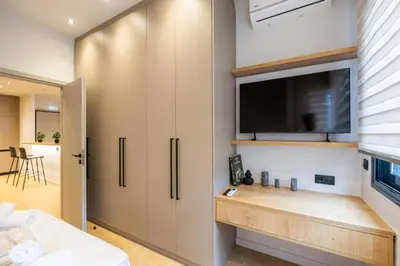a bedroom with a tv on a wall at Rooms151 Smart Suite in the Heart of Athens 1st floor-2B in Athens
