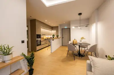 a living room and kitchen with a table and chairs at Rooms151 Smart Suite in the Heart of Athens 1st floor-2B in Athens