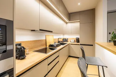 a kitchen with white cabinets and a table and a chair at Rooms151 Smart Suite in the Heart of Athens 1st floor-2B in Athens
