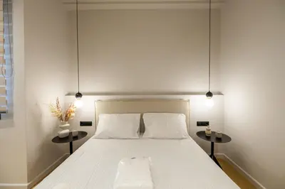 a bedroom with a white bed with two side tables at Rooms151 Smart Suite in the Heart of Athens 1st floor-2B in Athens