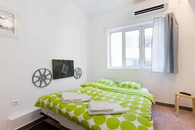 a bedroom with a green and white bed with a window at Circle Mirror Center Inn in Athens