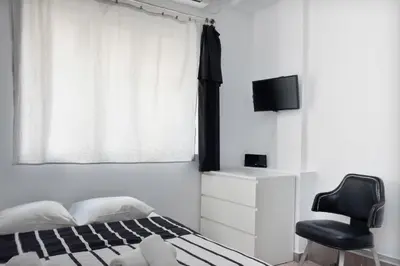 a bedroom with a bed and a chair and a window at Circle Mirror Center Inn in Athens