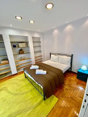 a bedroom with a large bed and a yellow rug at Cozy Apartment View Pasalimani in Piraeus