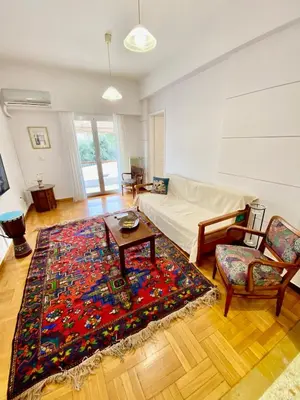 a living room with a couch and a table and a rug at Cozy Apartment View Pasalimani in Piraeus