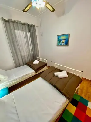 a room with two beds and a window at Cozy Apartment View Pasalimani in Piraeus