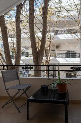 a chair and a table and a plant on a balcony at Apartment near Acropolis in Athens