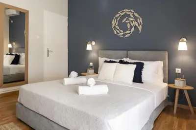 a bedroom with a large bed with two towels on it at Kosmos Serenity - 1BR, Neos Kosmos in Athens