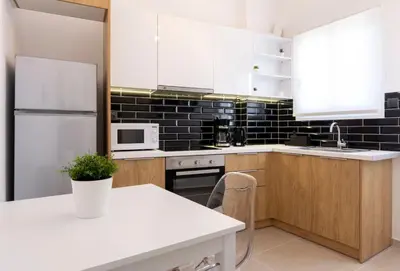 a kitchen with white appliances and a white table with a plant at Kosmos Serenity - 1BR, Neos Kosmos in Athens