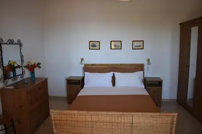 a bedroom with a bed and two tables and a mirror at Eriketi Studios in Agia Marina Aegina