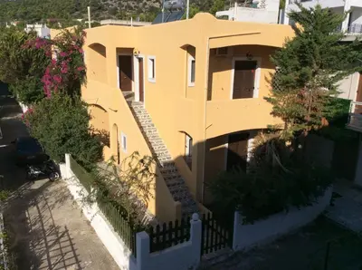 a yellow house with a fence in front of it at Eriketi Studios in Agia Marina Aegina