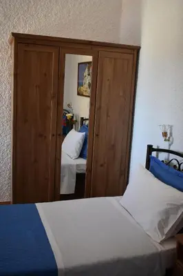 a bedroom with a bed and a mirror at Eriketi Studios in Agia Marina Aegina